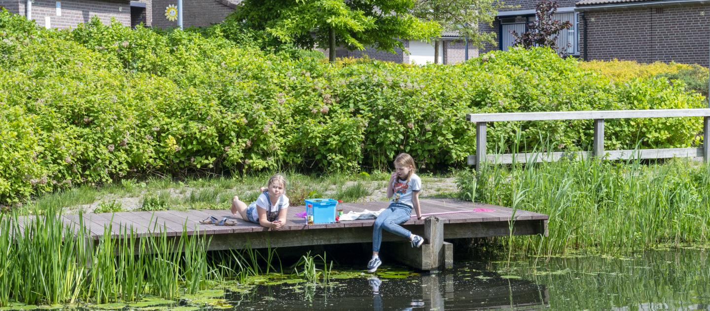 Twee kinderen op een steiger aan het water